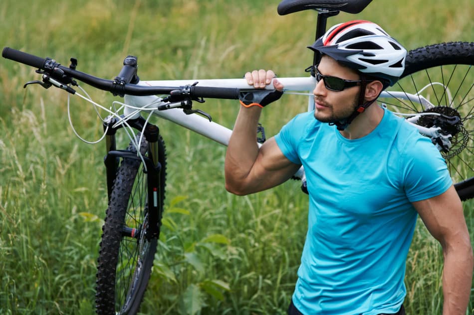 man carrying mountain bike