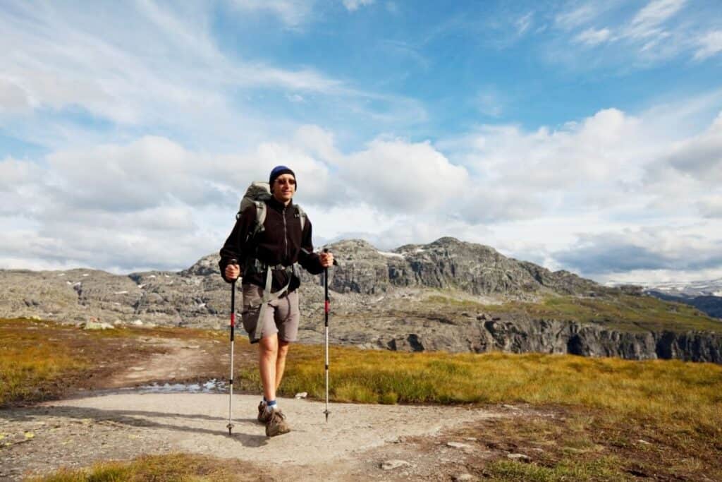 man hiking with trekking poles