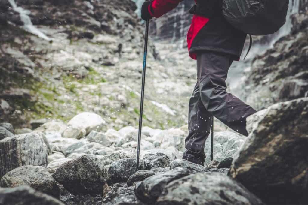 person hiking on snowy mountain with hiking poles