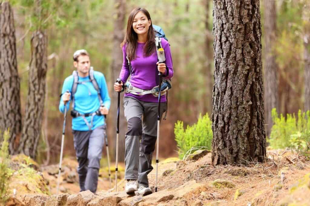 man and woman hiking through forest